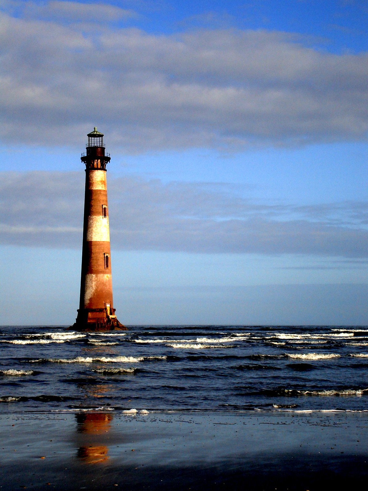 A red and white striped lighthouse on the coast